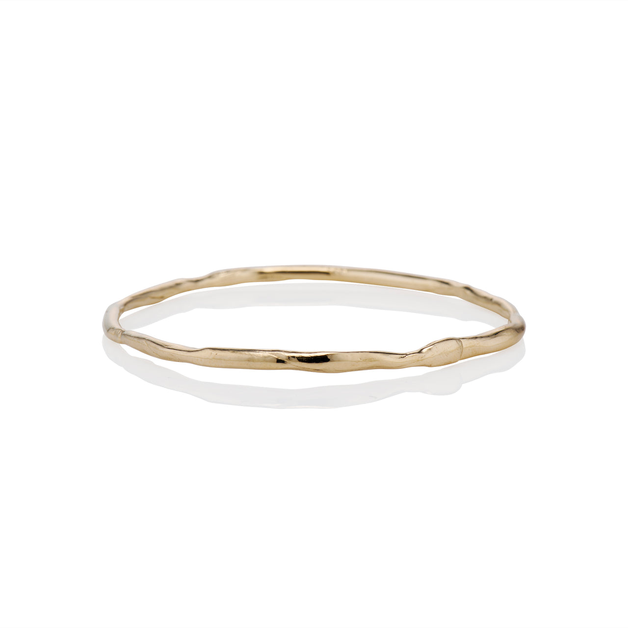 A gold bangle bracelet with a solid pattern and a shiny finish.